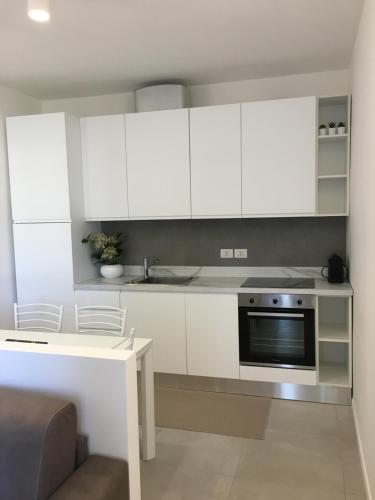 a kitchen with white cabinets and a sink and a stove at YOUR HOME MILANO Bellinzago Lombardo in Bellinzago Lombardo