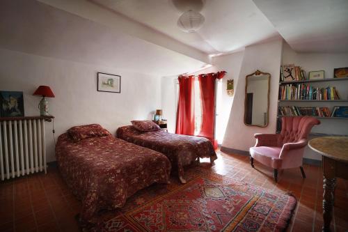 1 dormitorio con 2 camas, silla y espejo en Maison du Loup, en Ganges