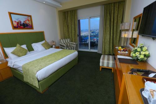 a hotel room with a bed and a large window at Tolip El Narges in Cairo
