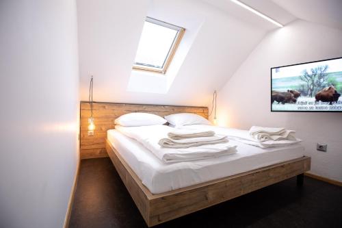 a bedroom with a bed with white sheets and a window at Becycle Sustainable stay and travel in Maribor