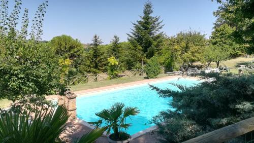 una piscina en un jardín con árboles en Agriturismo La Manonera, en Montepulciano