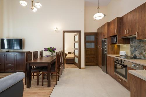 cocina y comedor con mesa y sillas en Vanilla 6 Apartment en Cracovia