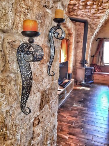 a stone wall with two mermaid lights on it at 19th Century Magical House in Galilee in ‘Eilabūn
