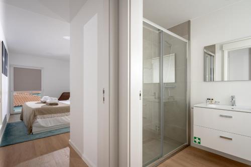 1 dormitorio y baño con ducha y lavabo. en The Wish São Roque en Ponta Delgada