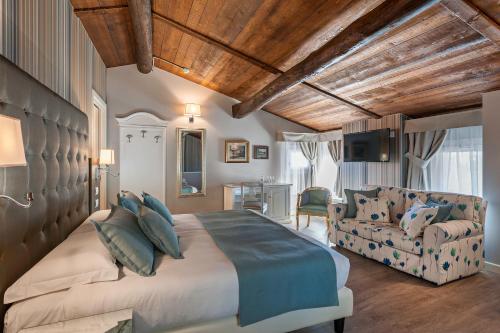1 dormitorio con 1 cama grande y 1 sofá en Borgo il Mezzanino, en Saló