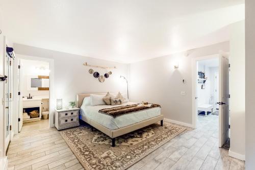 a white bedroom with a bed and a rug at Forest Creek 26 in Mammoth Lakes