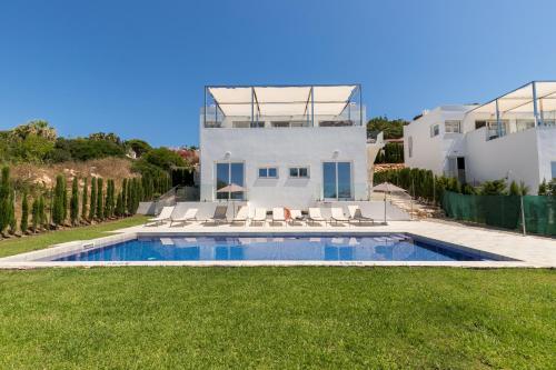 una casa con piscina junto a un patio en Villa Sunset, en Son Bou