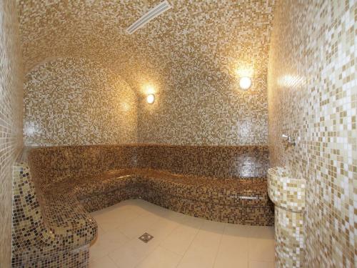 La salle de bains carrelée est pourvue d'une baignoire et de toilettes. dans l'établissement Arsenal Park Transilvania, à Orăştie