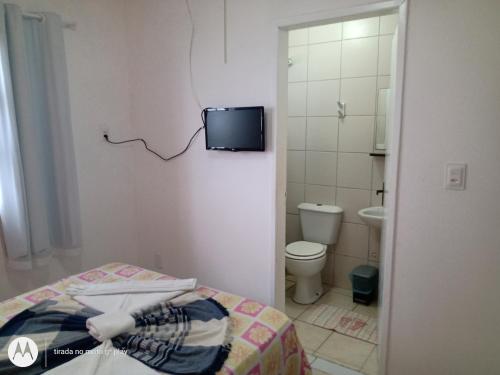 La salle de bains est pourvue d'un lit et d'une télévision murale. dans l'établissement Apartamentos beira mar, à Porto de Galinhas