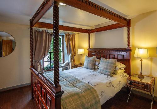 a bedroom with a canopy bed and a window at The Falls Of Dochart Inn in Killin