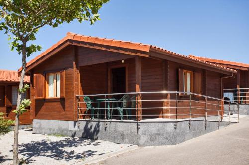 a wooden house with a porch and a balcony at Camping Paxariñas in Portonovo