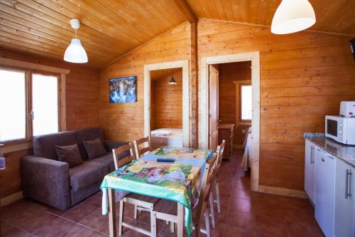 a dining room with a table and a couch in a room at Camping Paxariñas in Portonovo