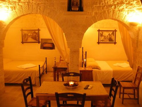 a room with two beds and a table with a candle at Trulli Resort Monte Pasubio in Alberobello