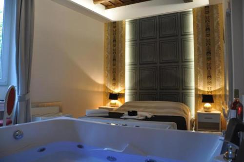 a bathroom with a bath tub and a bed at Hotelier 51 in Rome