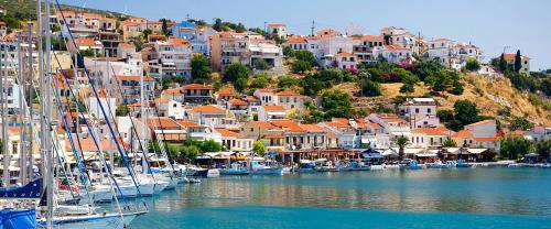 a group of boats docked in a harbor with houses at Hotel Damo in Pythagoreio