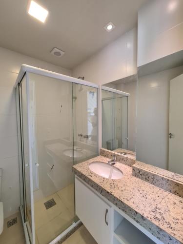 een badkamer met een wastafel en een douche bij PORTO AZUL - Praia do Forte - Apart in Cabo Frio