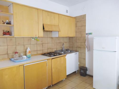 een keuken met houten kasten en een witte koelkast bij Centro Piave Apartment in Trento