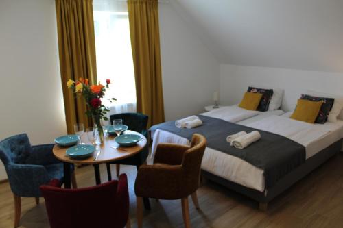 a bedroom with a bed and a table and chairs at Kucica u Šumi in Užice