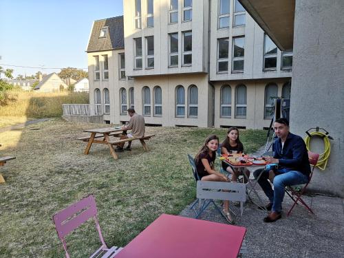 a group of people sitting at a table outside a building at AUBERGE DE JEUNESSE D'ORLEANS in Orléans