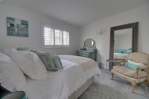 a bedroom with a bed and a chair and a mirror at Willow Cottage in Westerham