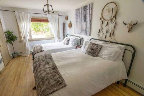 a bedroom with two beds and a clock on the wall at Banff Mountain Home- The Real Rockies Experience in Banff