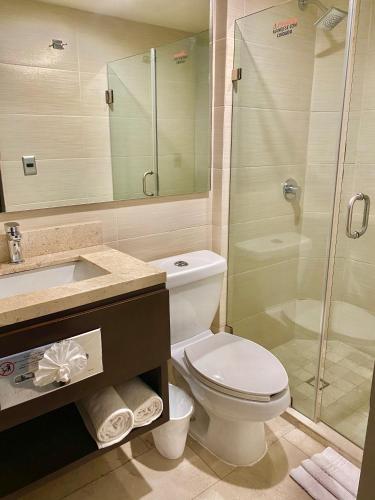 a bathroom with a toilet and a shower and a sink at Seven Crown La Paz Malecon in La Paz