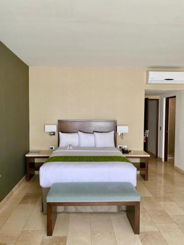 a bedroom with a large bed and two tables at Seven Crown La Paz Malecon in La Paz