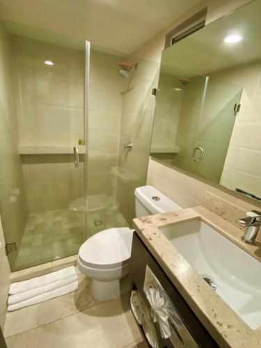 a bathroom with a toilet and a shower and a sink at Seven Crown La Paz Malecon in La Paz