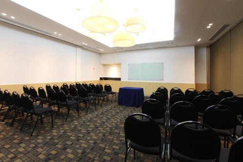 a conference room with chairs and a white screen at Fiesta Inn Insurgentes Viaducto in Mexico City