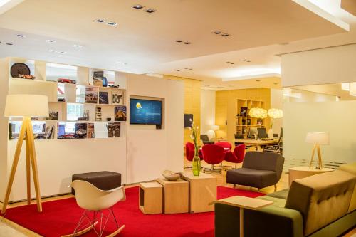a living room filled with furniture and red chairs at Fiesta Inn Insurgentes Viaducto in Mexico City