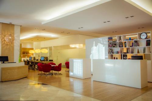 a living room with red chairs and a dining room at Fiesta Inn Insurgentes Viaducto in Mexico City