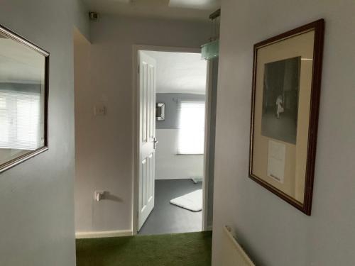 pasillo con baño con espejo y puerta en Mackworth House Farm, en Derby