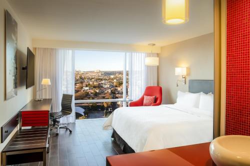 a hotel room with a bed and a large window at Fiesta Inn Express Queretaro Constituyentes in Querétaro