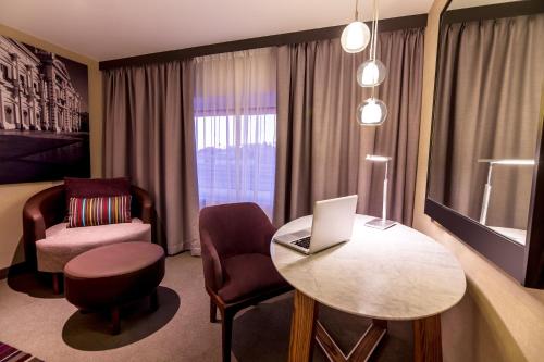 a hotel room with a table and a laptop on it at Fiesta Americana Hermosillo in Hermosillo