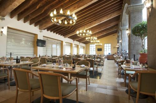 a restaurant with wooden ceilings and tables and chairs at Fiesta Inn Toluca Tollocan in Toluca