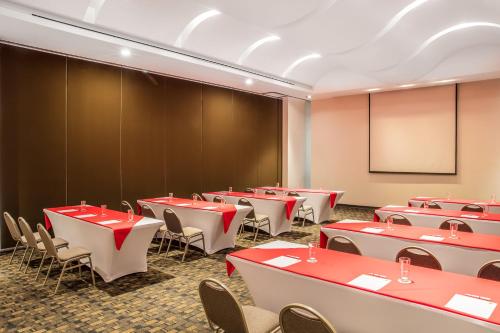 a conference room with tables and chairs and a chalkboard at Fiesta Inn Silao Puerto Interior in Silao
