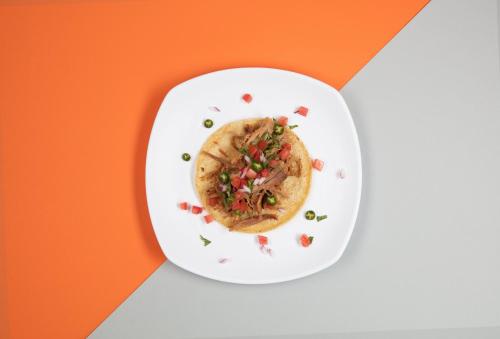 a plate of food on an orange and white background at One Ciudad de Mexico Alameda in Mexico City