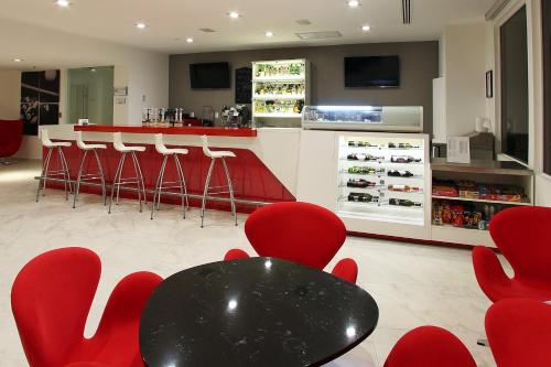 a bar with red chairs and a black table andools at Fiesta Inn Express Perinorte in Mexico City