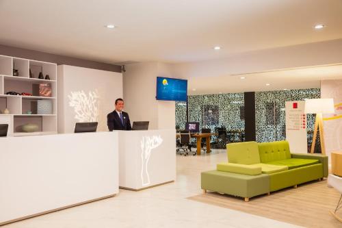 a man standing at a counter in an office at Fiesta Inn Express Perinorte in Mexico City