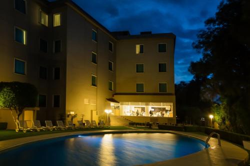 a hotel with a swimming pool in front of a building at Fiesta Inn Perinorte in Mexico City