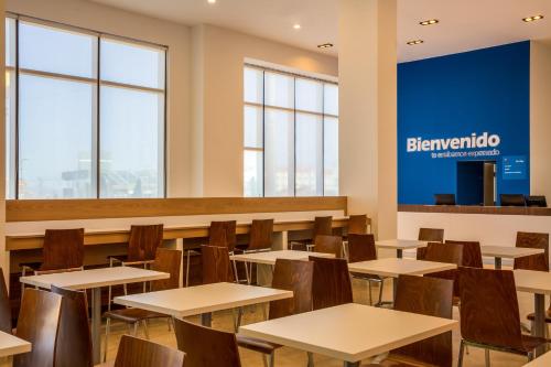 a classroom with tables and chairs and a sign that reads benzriento at One Chihuahua Fashion Mall in Chihuahua