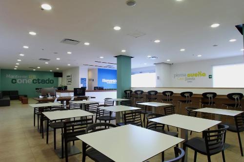 una caffetteria vuota con tavoli e sedie di One Queretaro Centro Sur a Querétaro