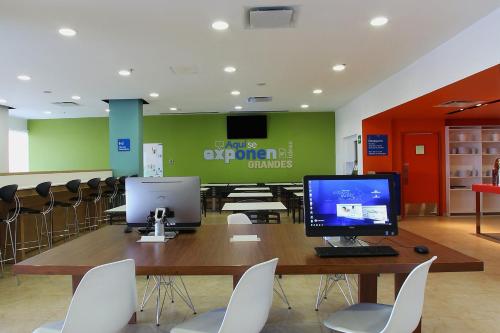 una sala de conferencias con escritorio y ordenador. en One Queretaro Centro Sur en Querétaro