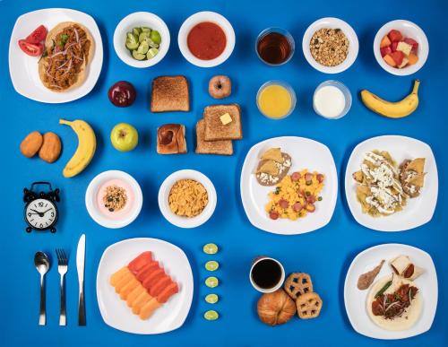 a collage of breakfast foods on plates on a blue background at One Puebla FINSA in Puebla