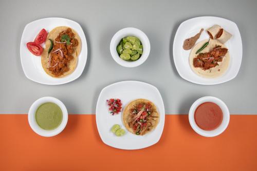 a table with plates of food and bowls of dips at One Cuautitlan in Cuautitlán