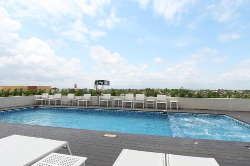a pool on the roof of a building with chairs at Fiesta Inn Merida in Mérida