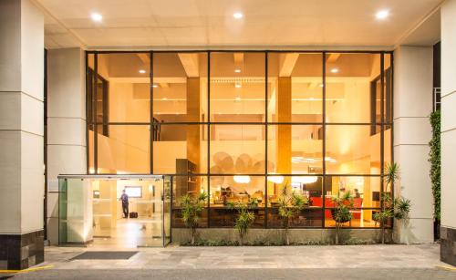a glass facade of a building with a person walking into it at Fiesta Inn Ciudad de México Aeropuerto in Mexico City