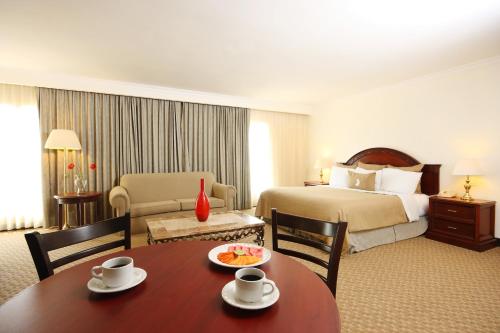 een hotelkamer met een bed en een tafel en stoelen bij Fiesta Inn Nuevo Laredo in Nuevo Laredo