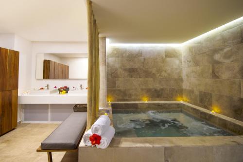 a bathroom with a bath tub with a sink and a tub at Fiesta Americana Cozumel All Inclusive in Cozumel