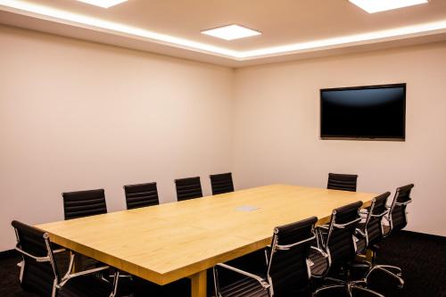 a conference room with a large wooden table and chairs at Fiesta Inn San Luis Potosi Glorieta Juarez in San Luis Potosí